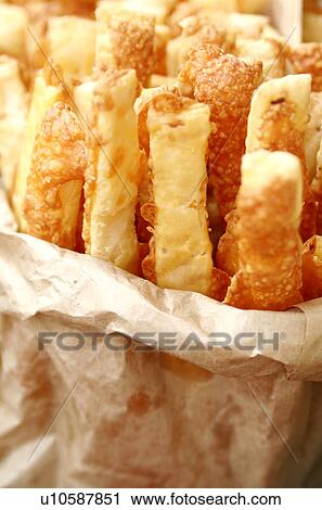 Stock Image - Cheese straws, a paper bag. Fotosearch