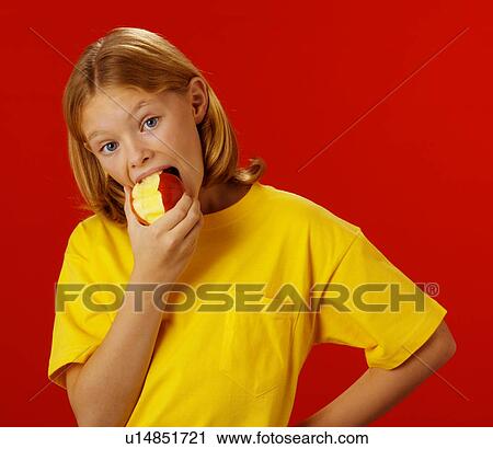 Stock Image - Young girl eating apple. Fotosearch