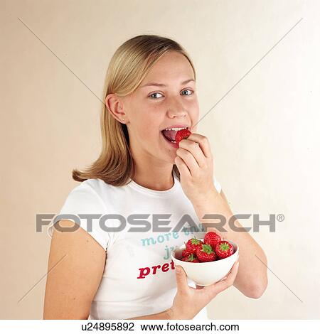 Stock Image - Child eating strawberries. Fotosearch