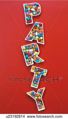 Picture - Party chocolate candies on Red - Non Exclusive. Fotosearch