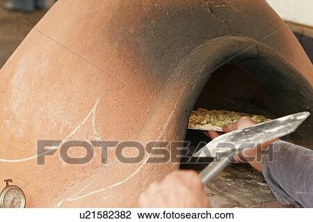 Person putting pizza into clay oven View Large Photo Image Stock Image - Person putting pizza into clay oven. Fotosearch