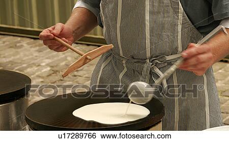 Stock Photograph - Pouring pancake mixture onto a hotplate. Fotosearch
