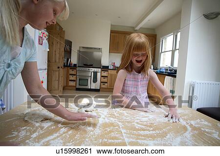 Stock Image - Young girls making pastry. Fotosearch