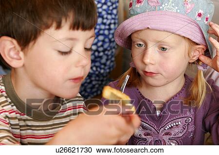 Stock Image - Boy and Girl Sharing Chips, Fish and Chip Shop. Fotosearch