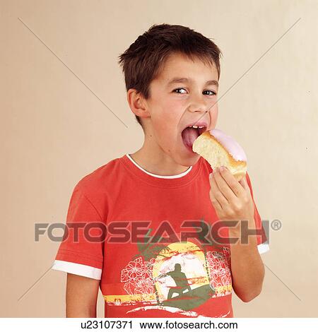 Stock Image - Child eating iced bun. Fotosearch