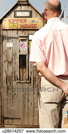 Man looking at fish smoking house (kipper house) View Large Photo Image Stock Photo - Man looking at fish smoking house (kipper house). Fotosearch