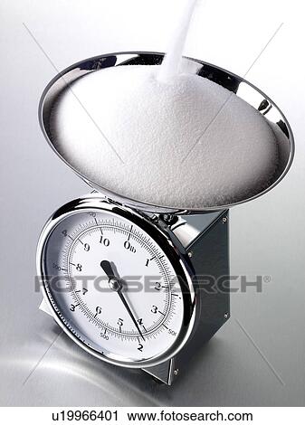 Stock Image - Salt Pouring Into Kitchen Scales - Non Exclusive. Fotosearch
