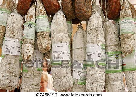 Stock Photo - Sweet salami and pork salami hanging on a market stall. Fotosearch