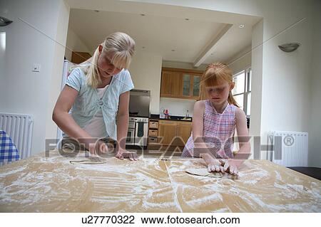 Stock Image - Young girls making pastry. Fotosearch