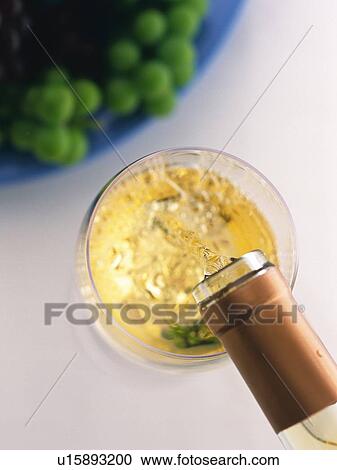 Stock Image - Poured White Wine and Grape, High Angle View. Fotosearch