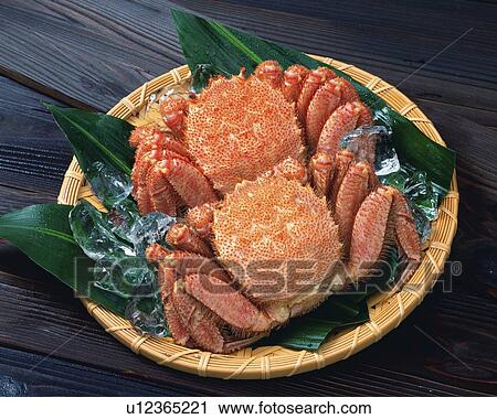 Stock Image - Hair crabs with ice on bamboo basket, high angle view. Fotosearch