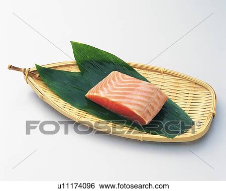 Stock Photograph - Salmon fillet on bamboo basket, high angle view. Fotosearch