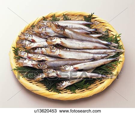 Stock Image - Shishamo smelts on bamboo basket, high angle view. Fotosearch