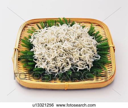 Stock Photograph - White baits on bamboo basket, high angle view. Fotosearch