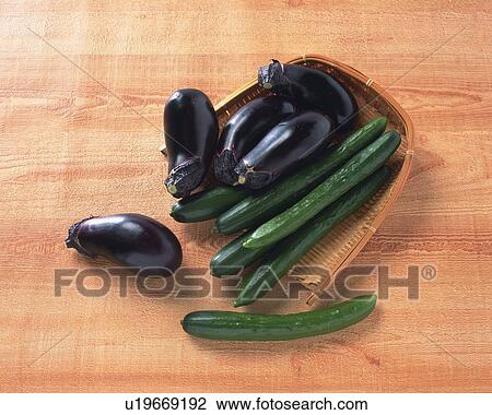 Stock Image - Cucumbers and Egg Plants on bamboo basket, high angle view. Fotosearch