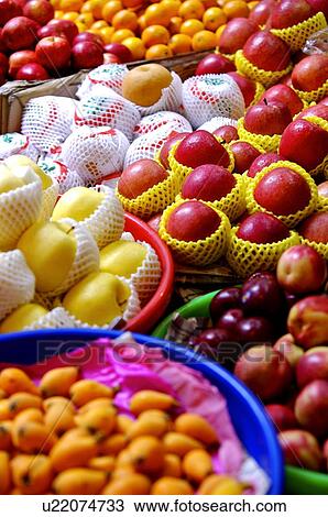 Stock Image - A variety of fresh fruit on display in plastic trays and boxes. Fotosearch