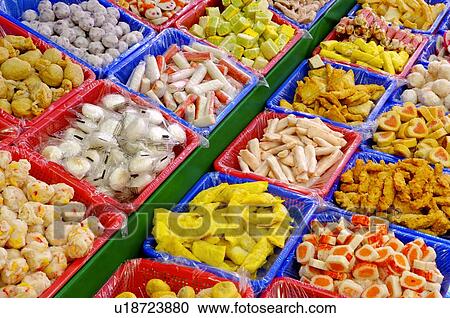 Stock Image - A variety of hot pot ingredients in plastic trays, on display in a market stall. Fotosearch