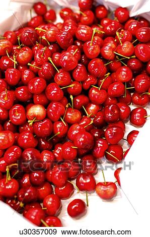 Stock Photo - Fresh red cherries in a box lined with tissue, close-up. Fotosearch