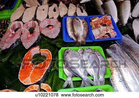 Fresh whole fish and raw fish steaks on display in a market stall View Large Photo Image Stock Photo - Fresh whole fish and raw fish steaks on display in a market stall. Fotosearch