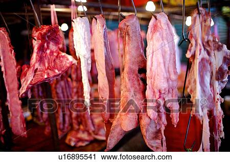 Pieces of raw pork hanging from metal hooks in a market stall View Large Photo Image Stock Image - Pieces of raw pork hanging from metal hooks in a market stall. Fotosearch