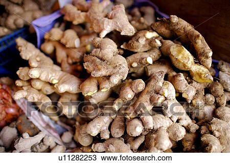 Stock Image - Raw ginger in baskets, on display in a market stall. Fotosearch