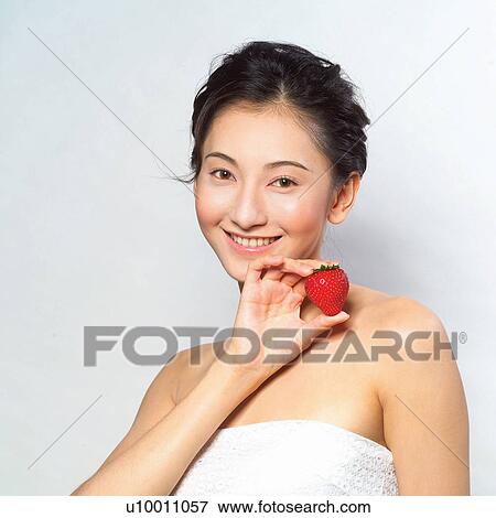 Asian woman eating a strawberry View Large Photo Image Stock Photo - Asian woman eating a strawberry . Fotosearch