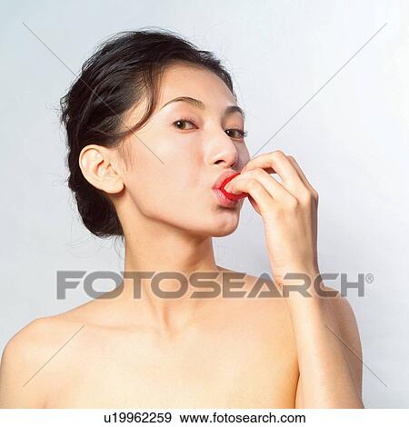 Stock Photo - Biting, Close-Up, Chili Pepper, Black Hair, Asian Ethnicity. Fotosearch