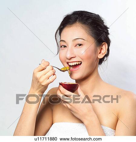 Stock Image - Refreshment, One Young Woman Only, Fruit, Happiness, Mouth Open, Asian Ethnicity. Fotosearch