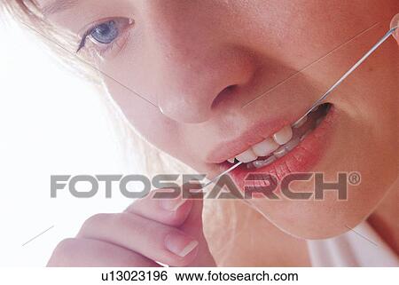 Stock Photograph - human teeth, flossing, dental hygiene, white background, holding. Fotosearch