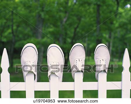 Stock Image - Deck Sneakers That are Hung Outside at the Fence, Front View, Differential Focus. Fotosearch