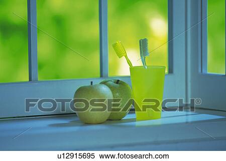 Stock Photography - Green Apple and Toothbrush at the Window Side, Front View, Differential Focus. Fotosearch