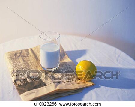 Stock Photograph - Milk, Lemon and Newspaper, High Angle View, Differential Focus. Fotosearch