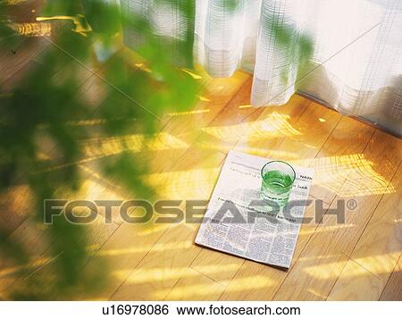 Stock Photograph - Newspaper and Glass on the Flooring, High Angle View, Soft Focus. Fotosearch