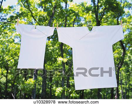 Two White T-Shirts that are Hung Outside in Nature, High Angle View, Differential Focus View Large Photo Image Stock Photo - Two White T-Shirts that are Hung Outside in Nature, High Angle View, Differential Focus. Fotosearch