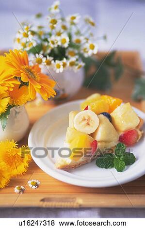 Stock Photo - Fruit Cake on the Plate and Flowers, High Angle View. Fotosearch