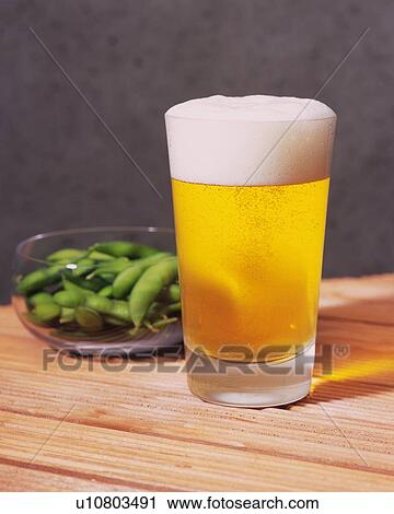 Stock Image - Beer and Green Soybeans, Front View, Differential Focus. Fotosearch