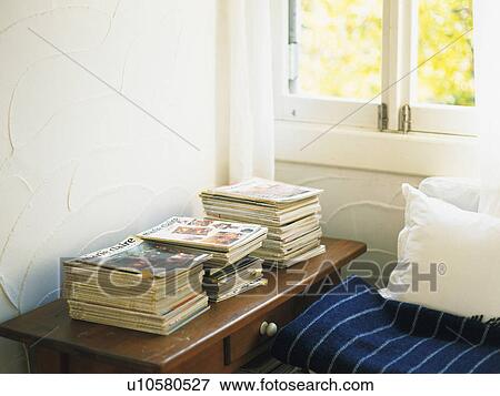 Stock Photo -  a Bedroom With Several Magazines on a Wooden Table Right Next to the Window, High Angle View. Fotosearch