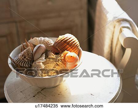 Stock Photography -  a Bowl Filled With Shells Standing on a Little Table, High Angle View. Fotosearch
