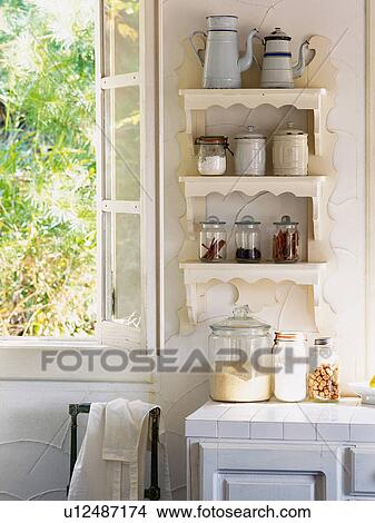Picture -  a Kitchen With Several Pots Standing on a White Banquette Near an Open Window, Front View. Fotosearch