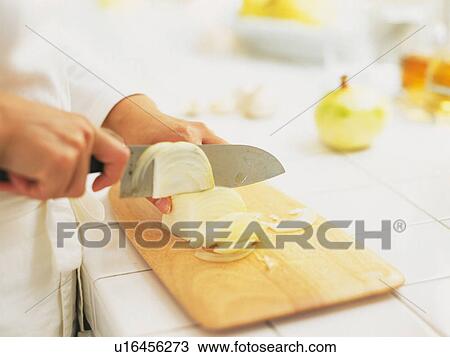 Stock Image -  a Person Cutting an Onion Into Pieces, High Angle View, Differential Focus. Fotosearch