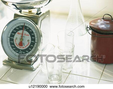 Stock Image -  a Scale, Several Little Glasses and a Brown-colored Pot, High Angle View. Fotosearch