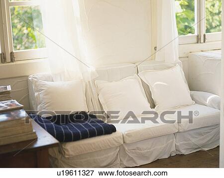 Stock Photo -  a White-colored Couch in a Living Room Right Next to the Window, High Angle View. Fotosearch