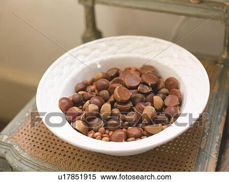 Stock Photography -  a White Plate Full of Chestnuts, Standing on a Wooden Chair, High Angle View. Fotosearch