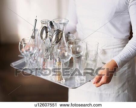 Stock Image -  a Woman Holding a Plate Full of Glasses, High Angle View. Fotosearch