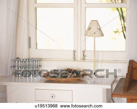 Stock Photo -  a Wooden Plate Full of Different-colored Stones Standing on a White Cabinet Near the Window, High Angle View. Fotosearch