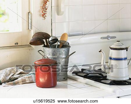 Stock Photography -  Several Kitchen Items in a Silver Bucket Near a Hearth, Front View. Fotosearch
