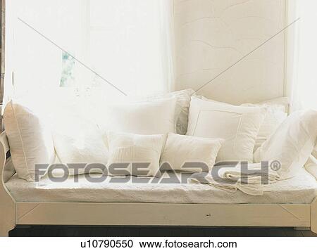 Several White Cushions on a White Sofa Near a Window, Front View View Large Photo Image Stock Image - Several White Cushions on a White Sofa Near a Window, Front View. Fotosearch