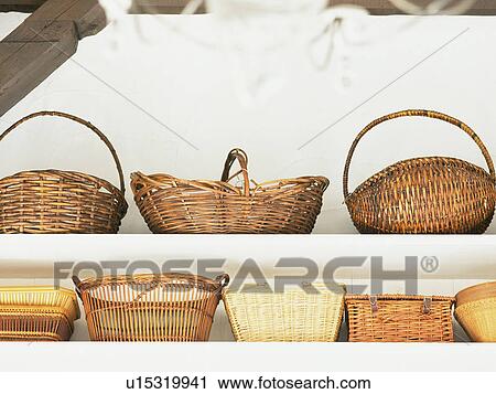 Stock Image -  Several Wooden Baskets Standing on a White Banquette, Low Angle View. Fotosearch