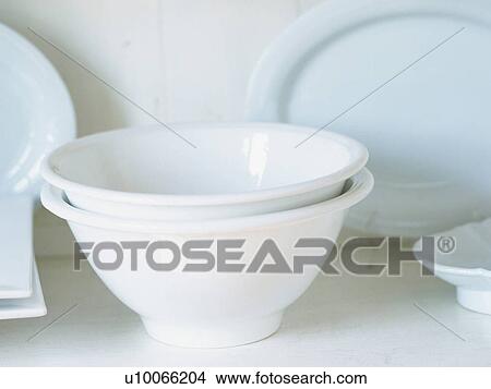 Picture -  Two Porcelain Bowls, Next to Several Other White Dishes. Fotosearch