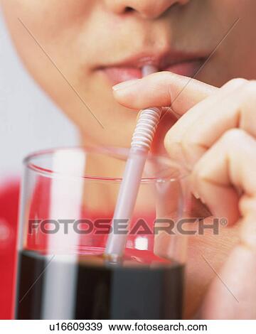 Stock Photo - A Woman Drinking a Glass of Juice, Front View, Close Up. Fotosearch